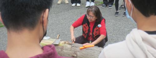 Elder Alice Guss harvests a cedar log